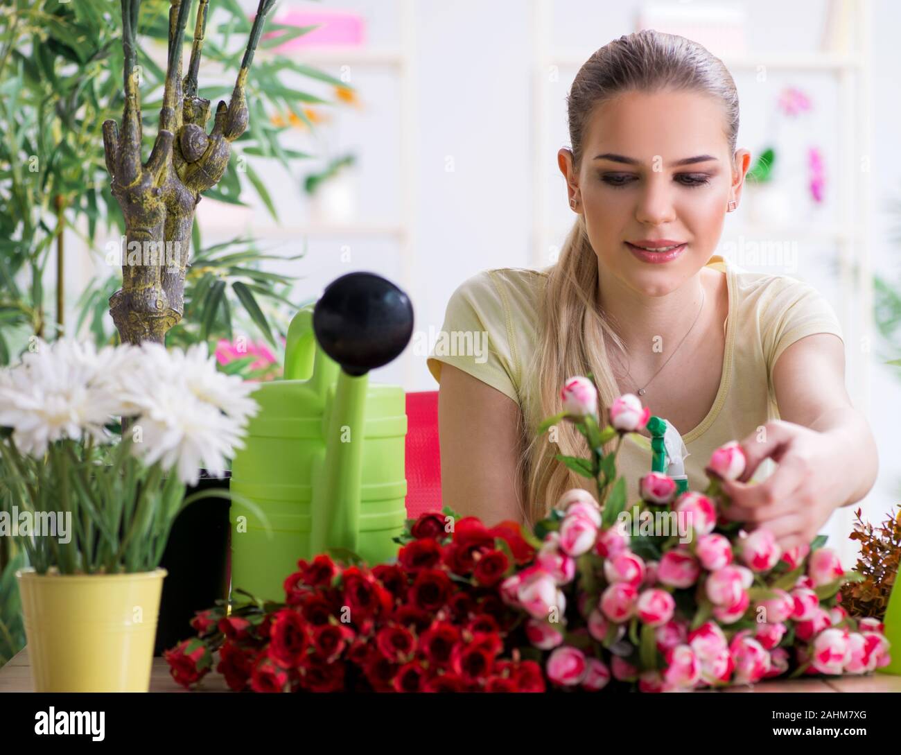 The young woman watering plants in her garden Stock Photo - Alamy
