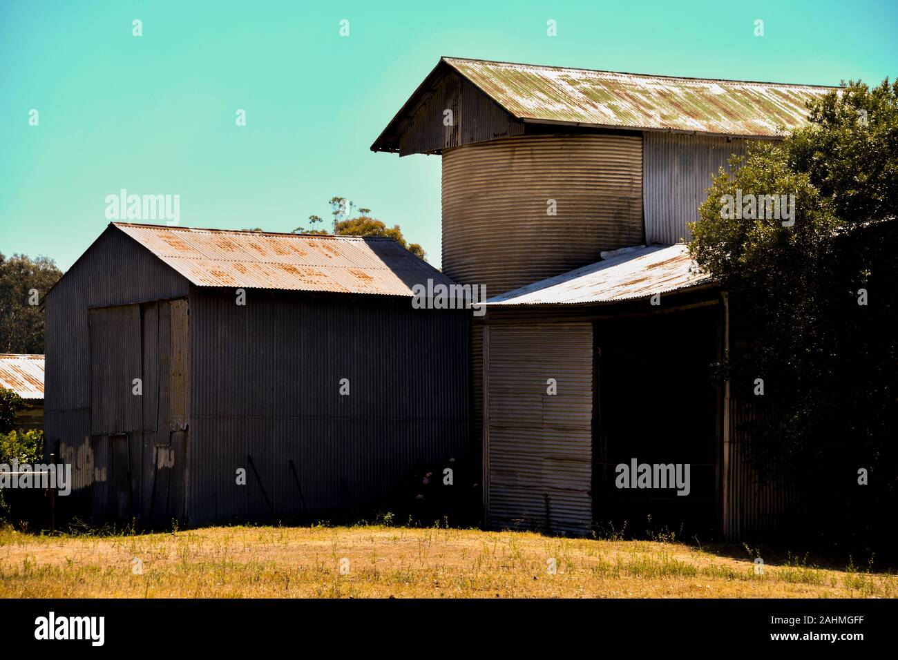 Old Rusted Corrugated Iron Barn Sheds with Silo on Farm Stock Photo