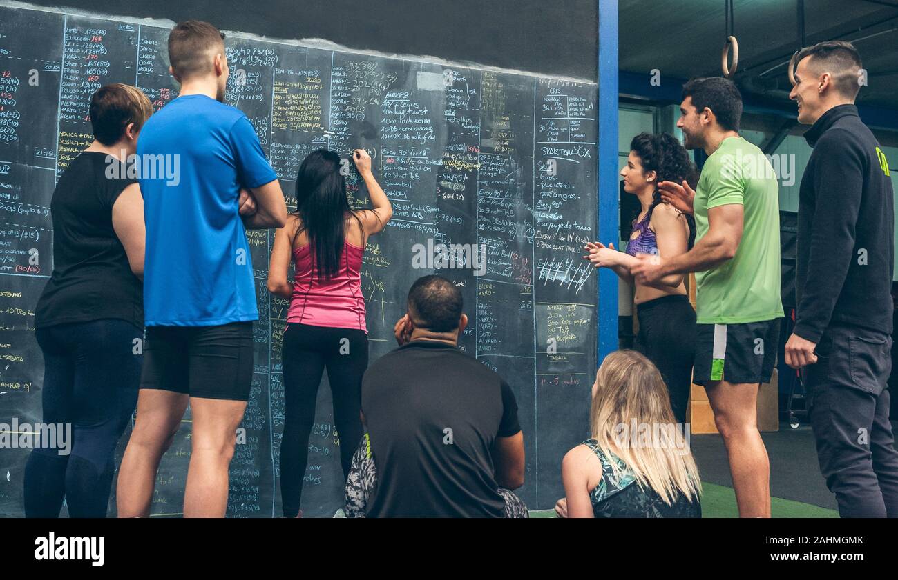 Athlete woman writing down results on the gym blackboard Stock Photo