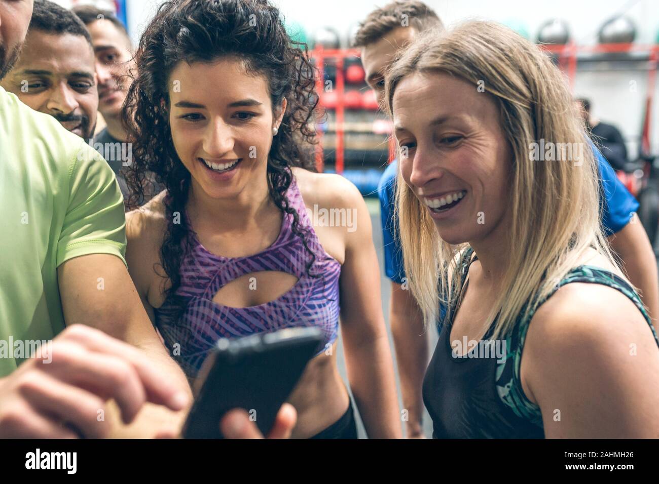 Athletes looking at the mobile of a gym mate Stock Photo