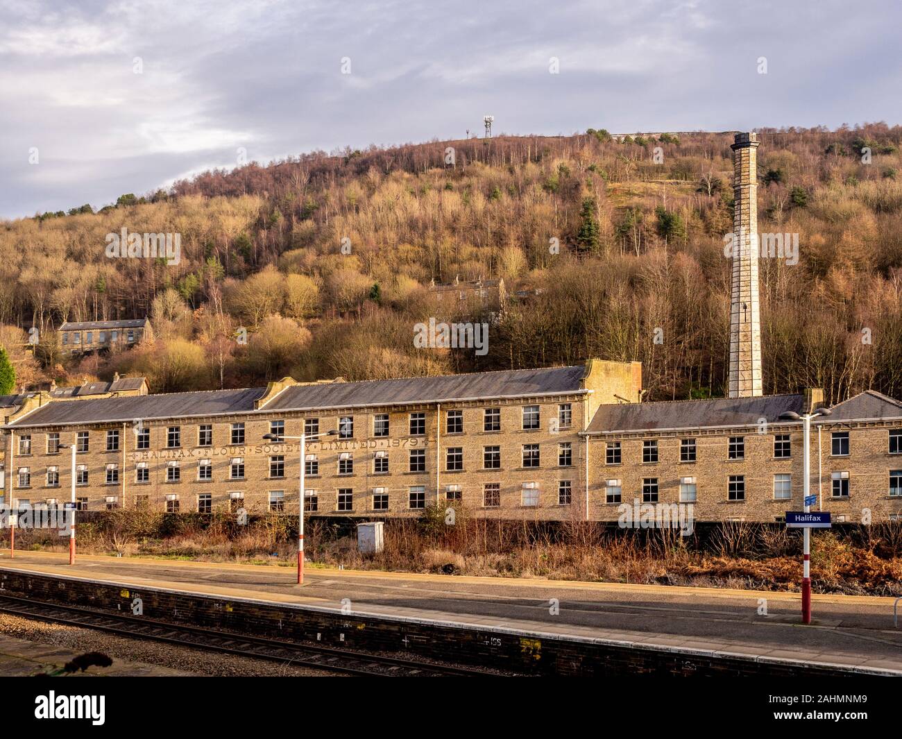 Halifax Flour Society Mill building -  a co-operative mill founded in 1879, Halifax, UK. Halifax train station platform in foreground. Stock Photo