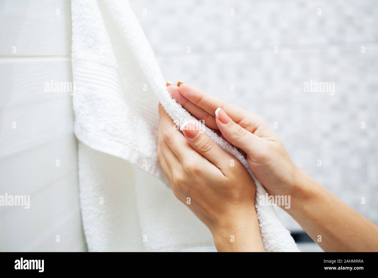 https://c8.alamy.com/comp/2AHMRRA/close-up-hands-use-white-towel-in-light-bathroom-2AHMRRA.jpg