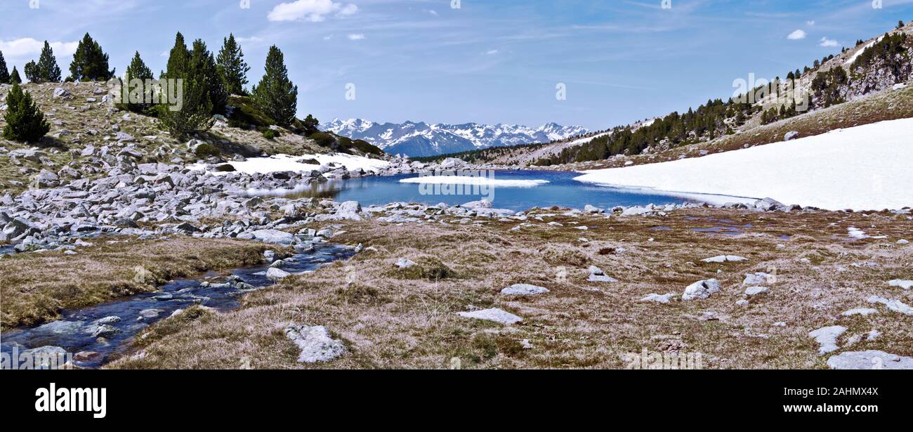 Panorama from top of Madriu-Perafita-Claror Valley in the stream and the lake bordered with snow, the mountain chain of Andorran and Stock Photo - Alamy