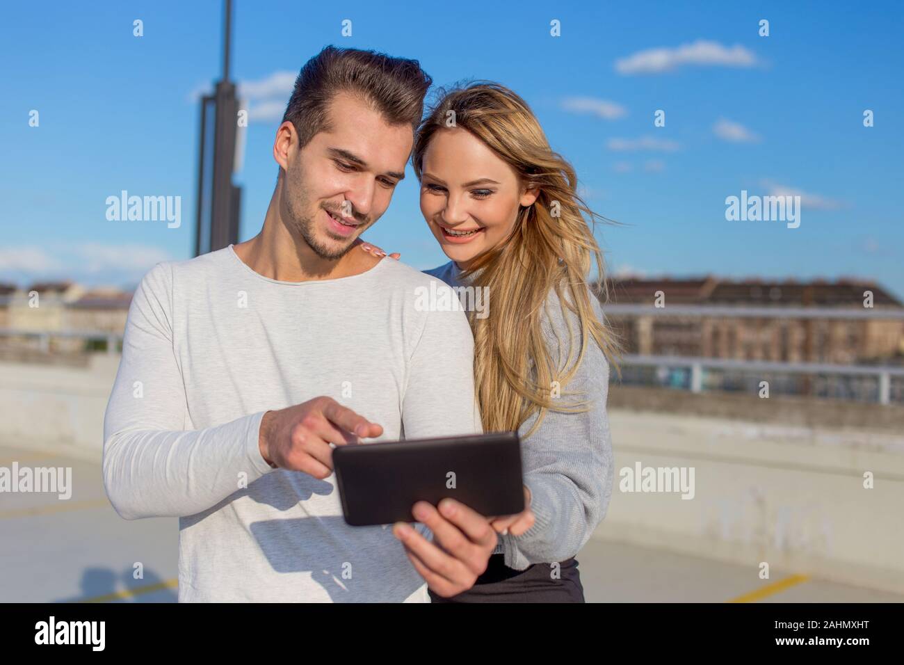 Happy young urban couple using digital tablet togerher, outdoors Stock Photo