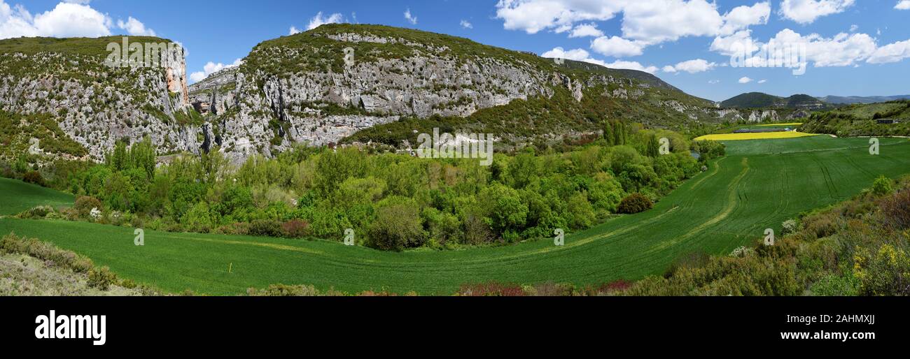 Panorama of Sierra de Leyre mountain chain and the entrance to the Lumbier Canyon, Cultivated fields and meadows are at foreground. Stock Photo