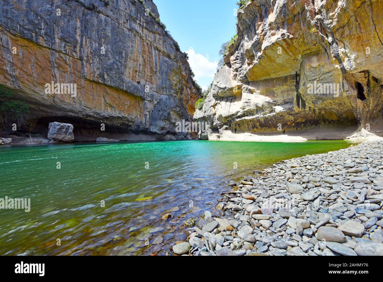 The flow of Irati River passing between walls and grottos of Lumbier Canyon, which makes a part of Sierra de Leyre mountain chain in Pyrenees of Spani Stock Photo