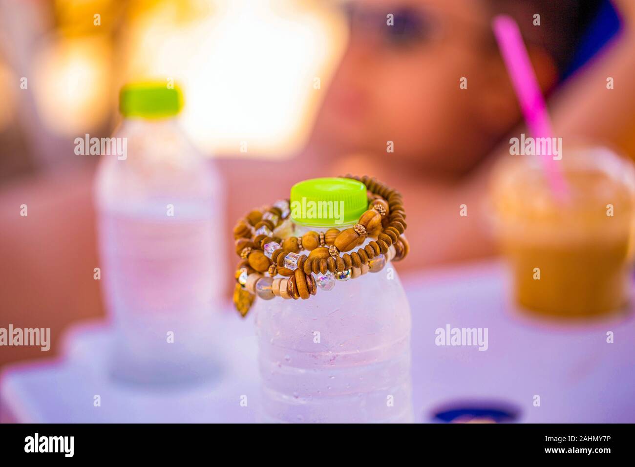Bracelet on bottle of water on beach closeup, depth of field Stock Photo