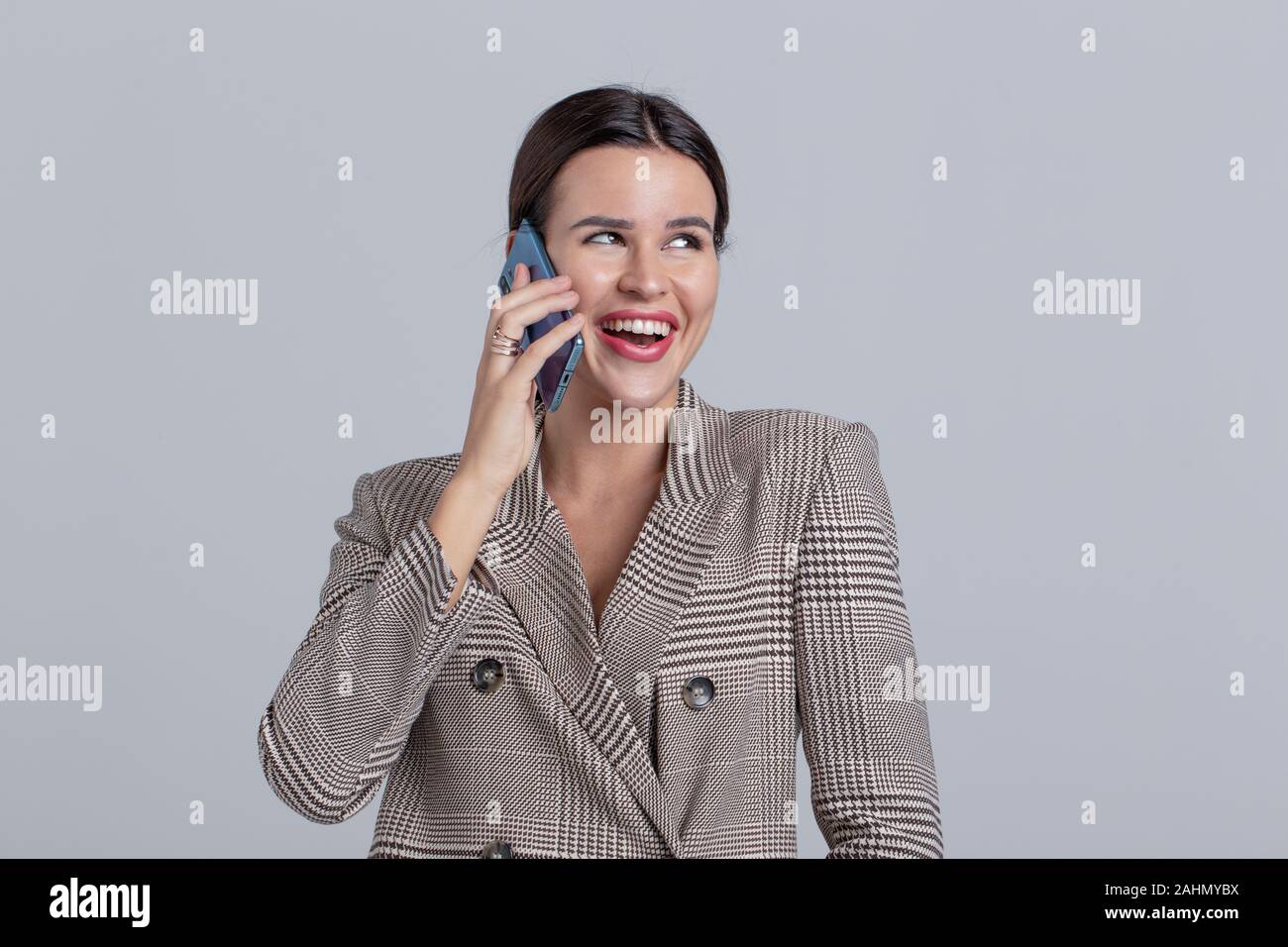 Professional young successful businesswoman in gray formal wear calling Stock Photo