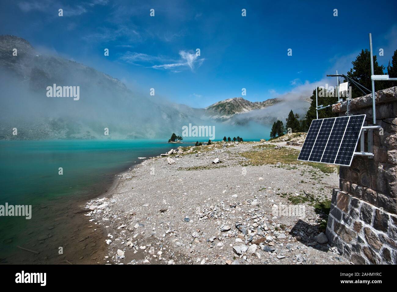 The border of Aubert lake in Neouvielle Natural reserve, the service cabin at right equipped with the solar cell panel, the lake and mountain slopes h Stock Photo