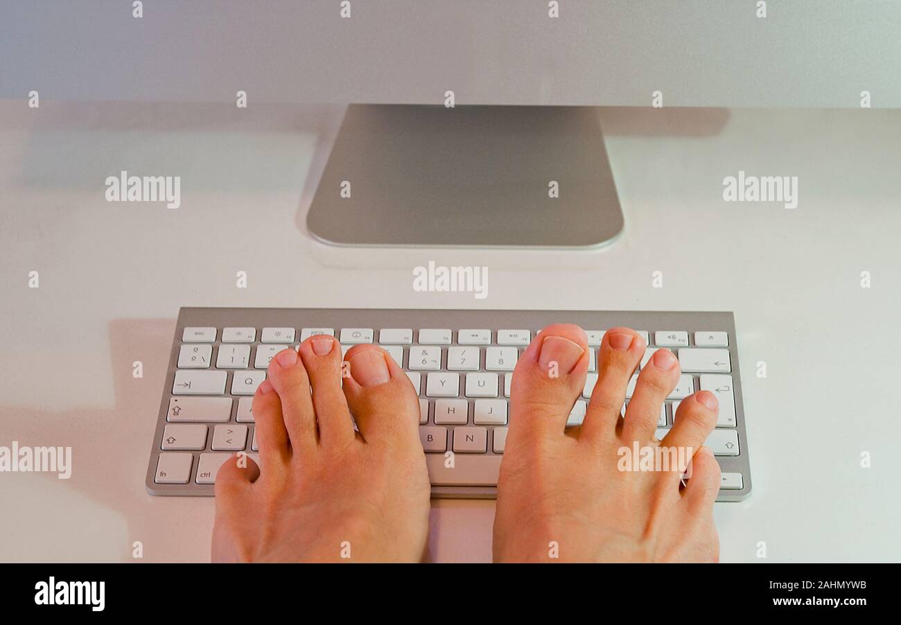 Man's feet typing keyboard Stock Photo Alamy
