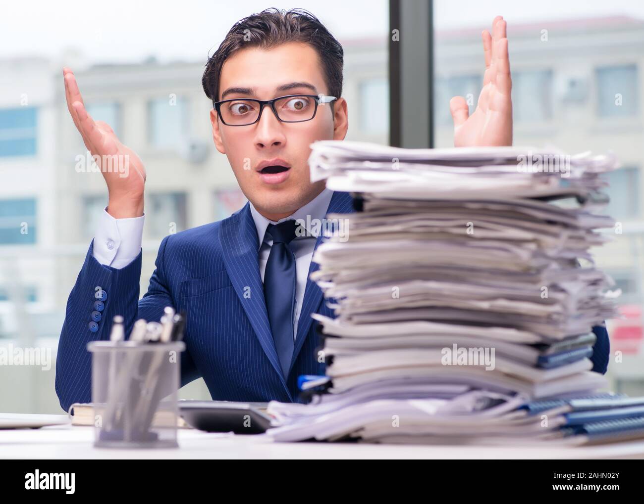 The workaholic businessman overworked with too much work in office ...