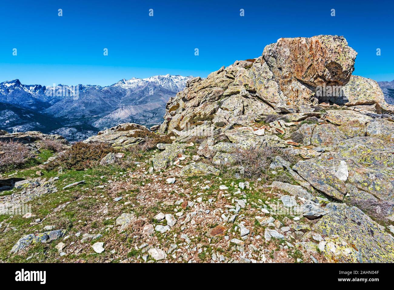 Rocks of Capu di u Facciatu mountain slope in Niolo region in Central Corsica, Monte Cinto mountain massif is at background, Natural Regional Park of Stock Photo