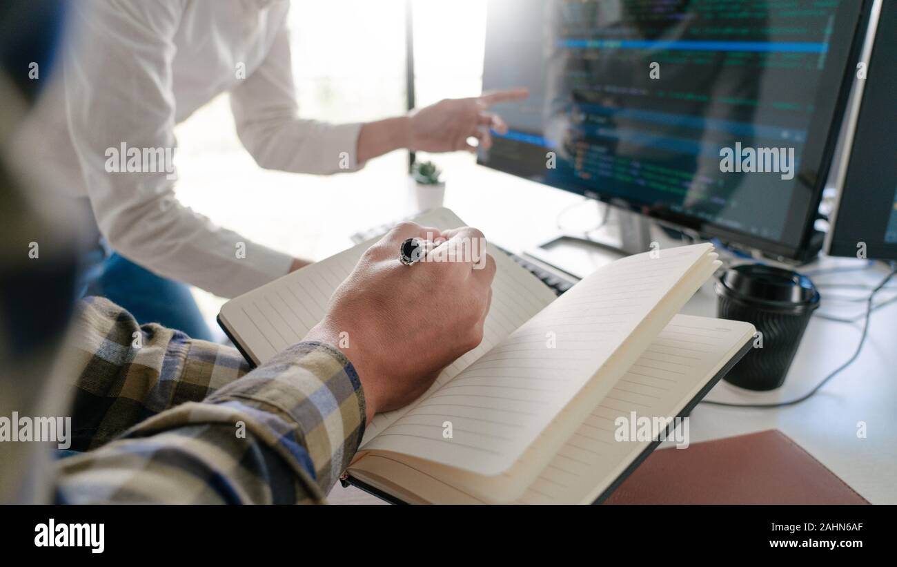 Young startup Programmers Sitting At Desks Working On Computers screen for Developing programming and coding to find solution to problem on New Applic Stock Photo