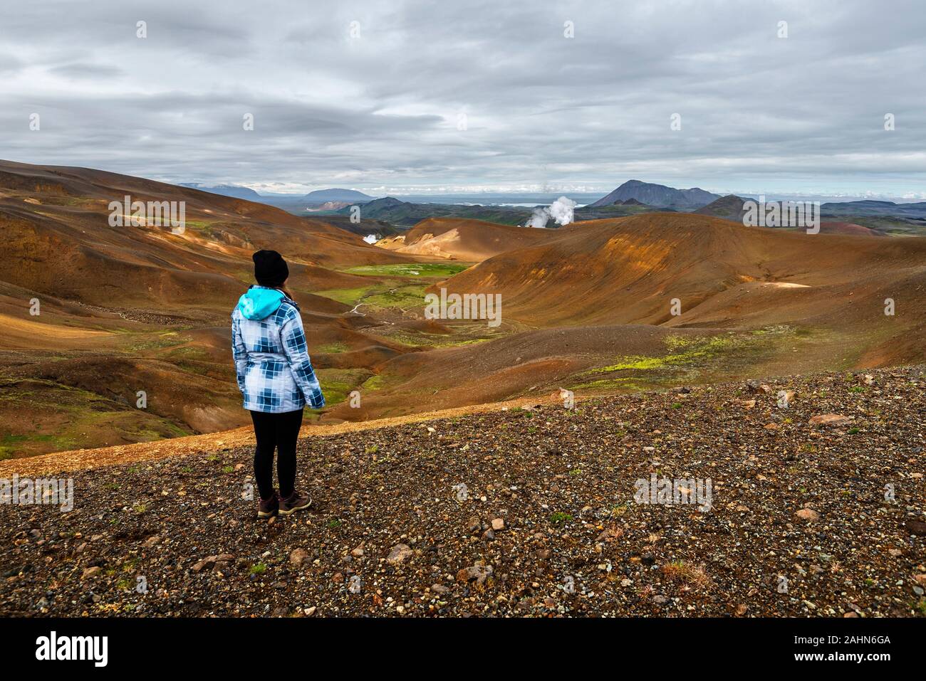 Girl teenager is staying in observing the landscape of Krafla volcanic area in Nordurland eystra region of  Northern Iceland Stock Photo