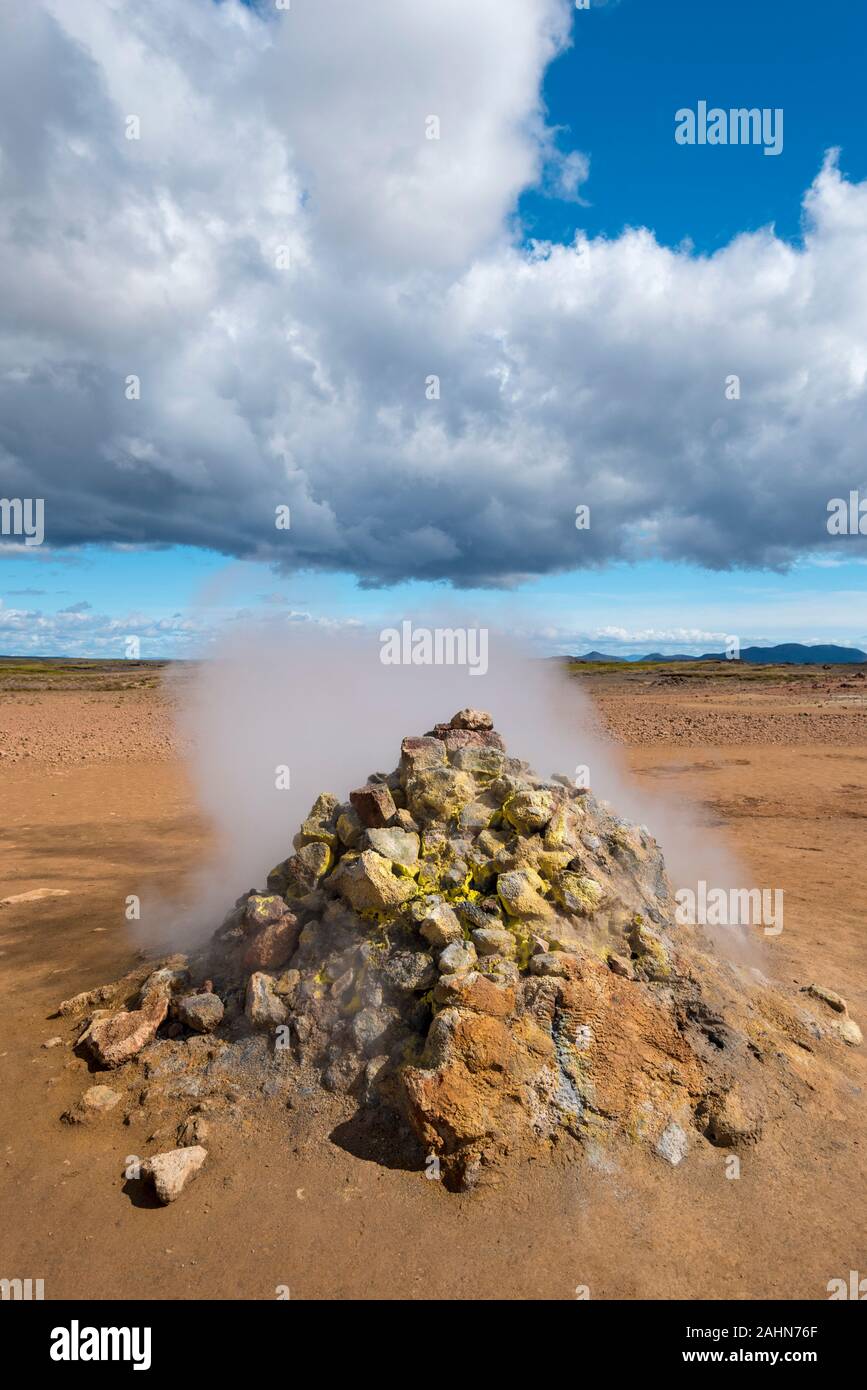 Solfatara type of active Fumarole in Hverarond hydrothermal site in Northern Island. Sulfur deposits are in the surface of rocks.  Cloudy sky is at ba Stock Photo