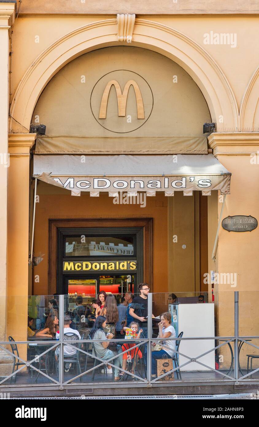 BOLOGNA, ITALY - JULY 10, 2019: People visit McDonald's restaurant in city historic center. It is an American fast food company, founded 1940 as a res Stock Photo