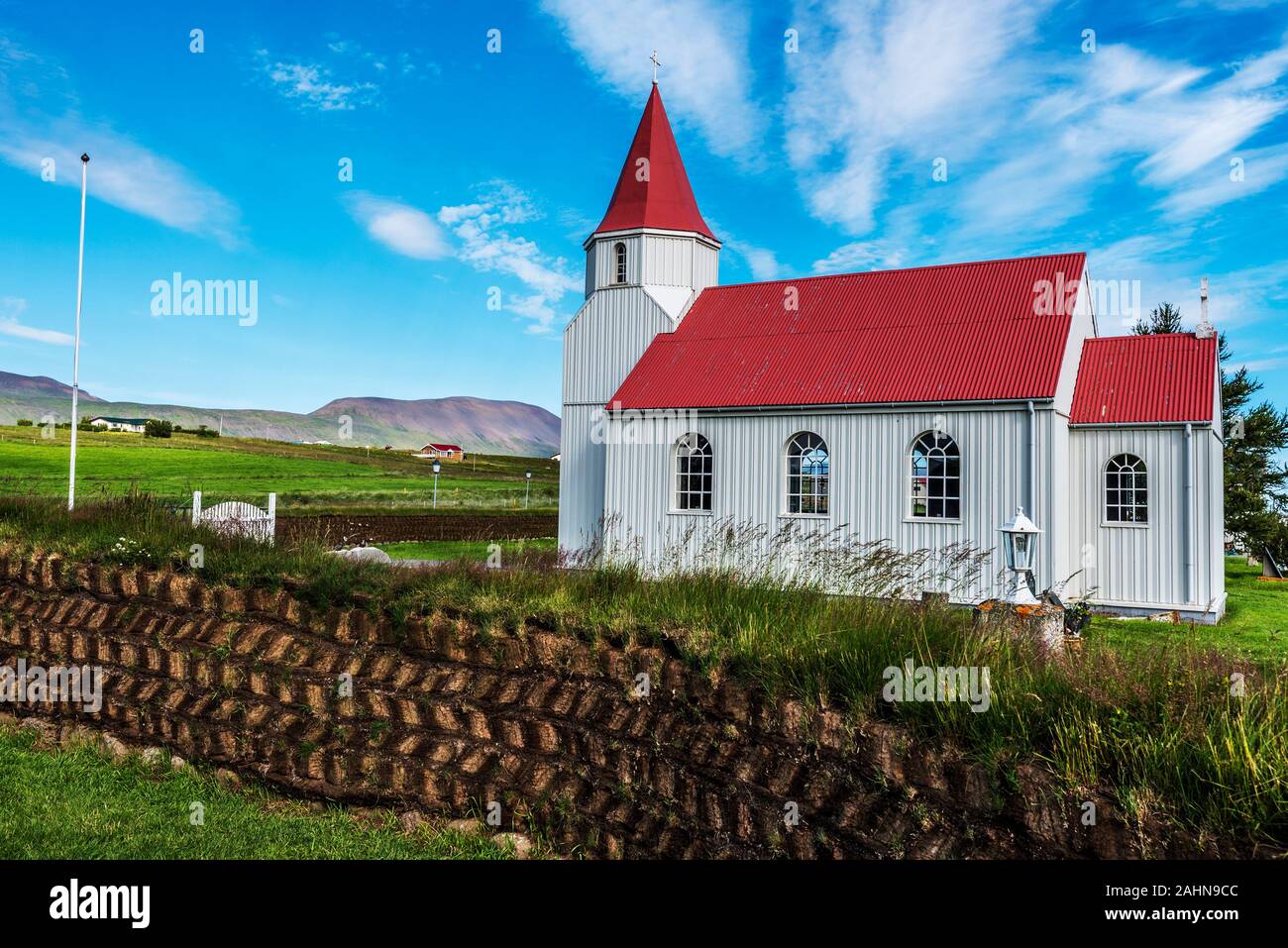 Wooden church in Glaumbaer farm in Northern Iceland.  The wall made with turf blocks is at foreground. Stock Photo