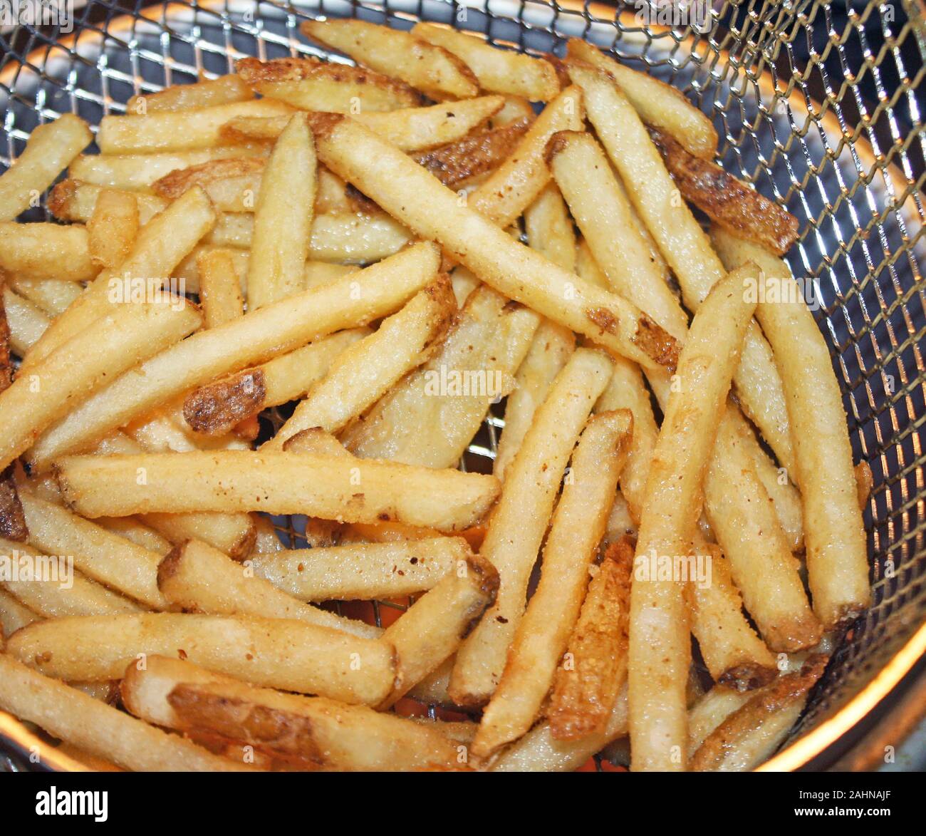 Crispy golden french fries in a deep fryer basket Stock Photo Alamy