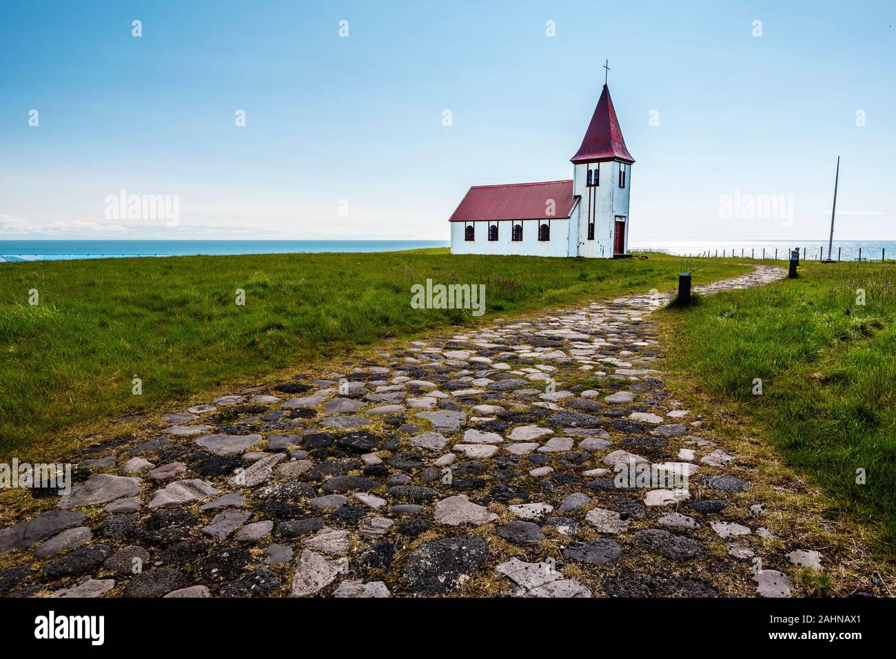 Pebble paved walk pass to Hellnar church in Snaefellsnes peninsula of Western Iceland. The ocean horizon is at background. Stock Photo
