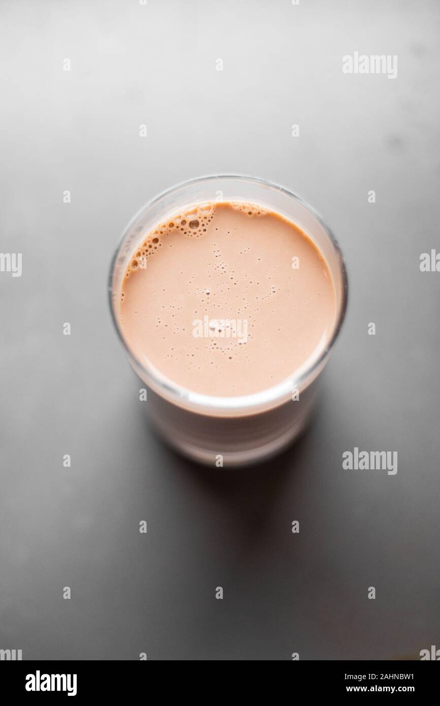 chocolate milk in glass cup with grey blurry background Stock Photo