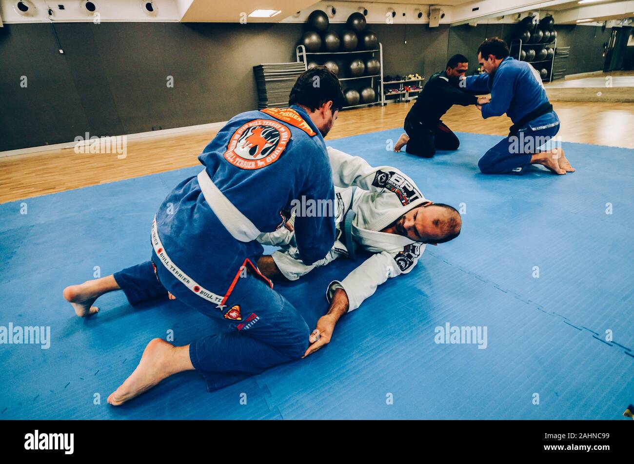 Two young men practice Brazilian Jiu-Jitsu sparring, a grappling type martial arts with a kimono gi - NOT STAGED Stock Photo