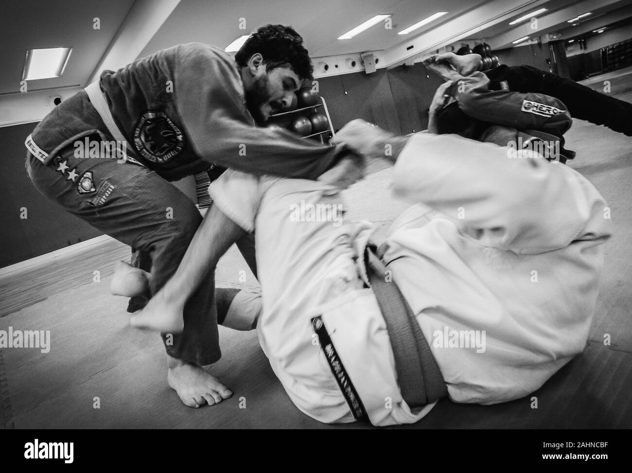 Two young men practice Brazilian Jiu-Jitsu sparring, a grappling type martial arts with a kimono gi - NOT STAGED Stock Photo