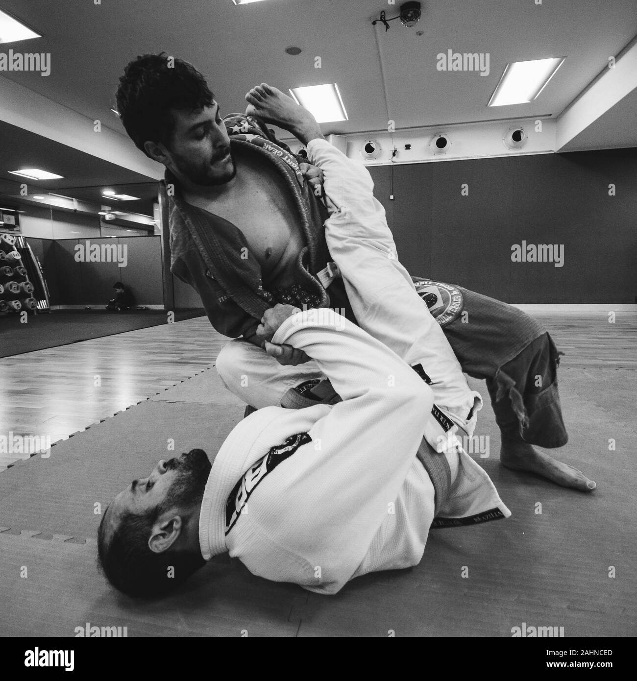 Two young men practice Brazilian Jiu-Jitsu sparring, a grappling type martial arts with a kimono gi - NOT STAGED Stock Photo