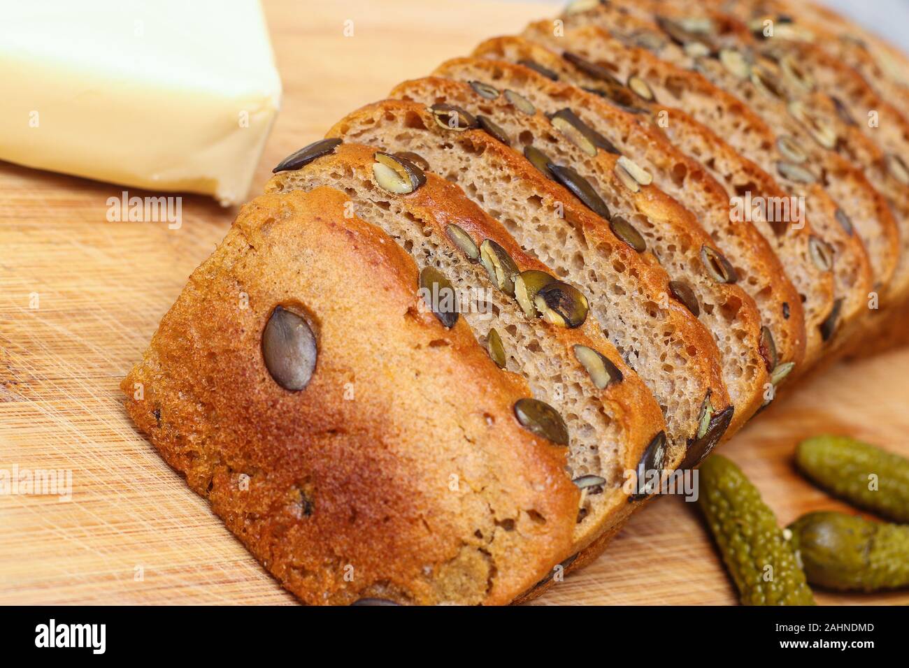Pre-sliced rye and wheat bread with pumpkin seeds on kitchen board Stock Photo