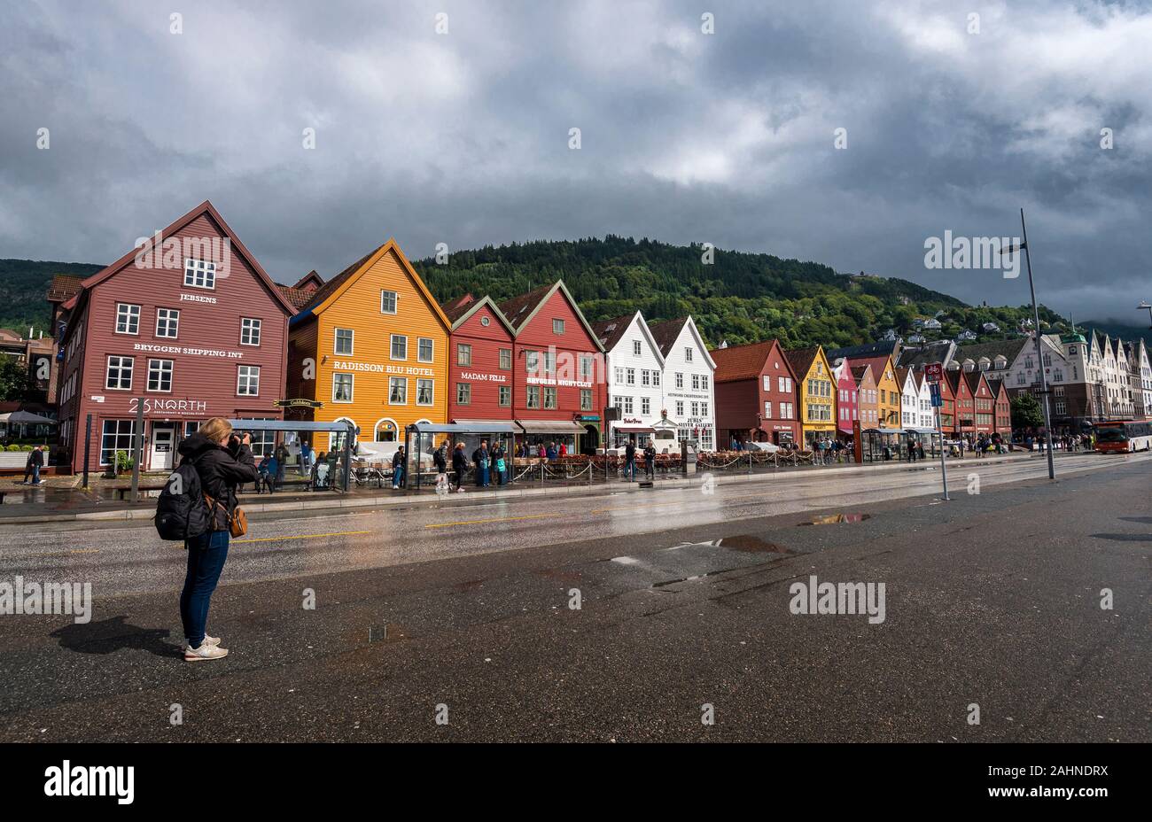 Bergen, Norway-July 27, 2017 Girl tourist talking picture of Hanseatic buildings of Bryggen, a World Heritage Site Stock Photo
