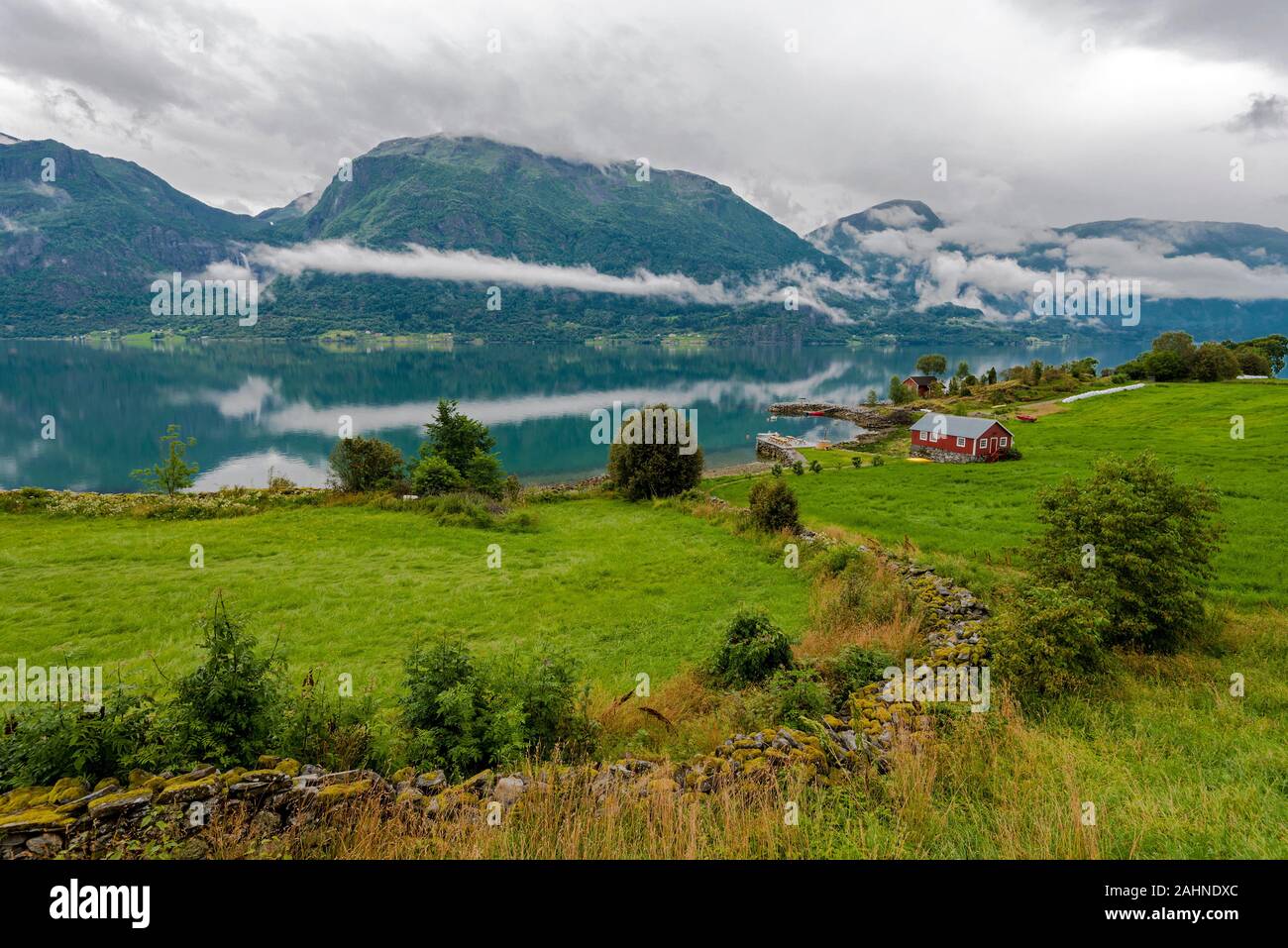 Landscape of Lustrafjorden in Hoyheimsvik area in Norway. Grassland and lonely house are in the border of the Fjord. Stock Photo