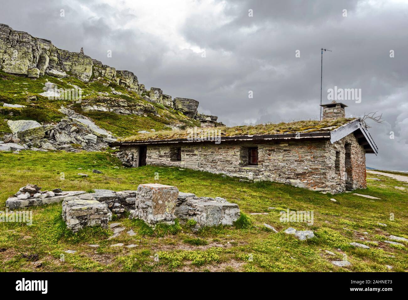 Ancient house of mine workers in Oppland highlands, Norway. Rocky slope of Gluggen hill is at background. Stock Photo
