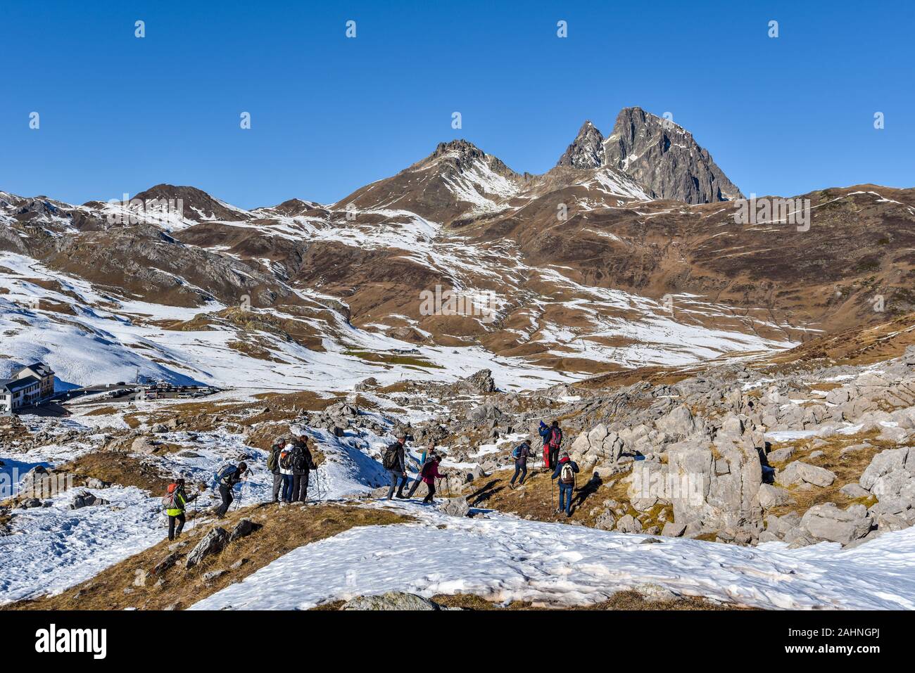 Portalet, France – January 1, 2019 People hikers moving along the mountain slope in French Atlantic Pyrenees. The early winter landscape of Portalet m Stock Photo