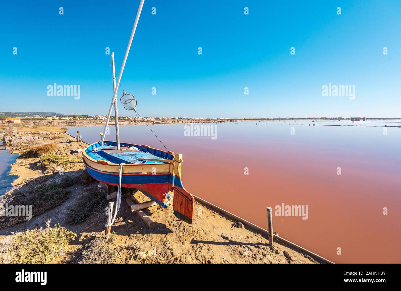 Saline island of Saint Martin de Gruissans, the old wooden ship at left and the reddish colored saturated with salt water at right.  Occitanie, France Stock Photo