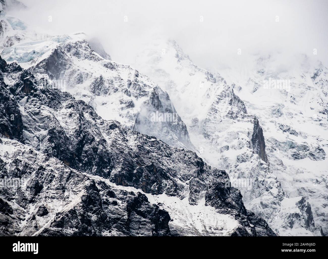 Himalayan Mountains In Fog Full Frame Of Snowy Mountain Ridges And Exposed Rock Stock Photo Alamy