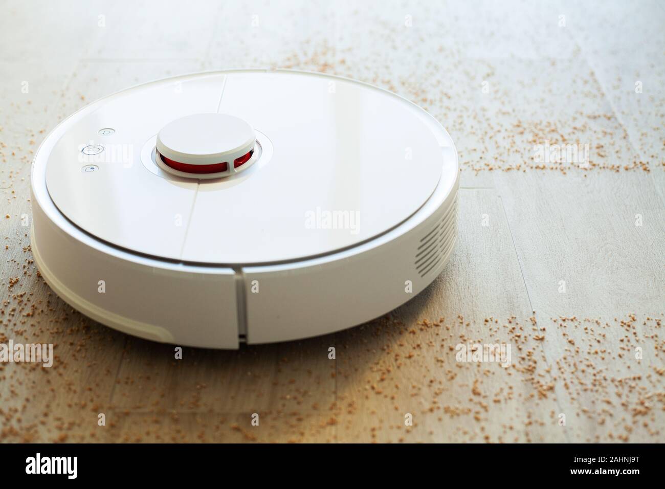 Smart House. Vacuum cleaner robot runs on wood floor in a living room