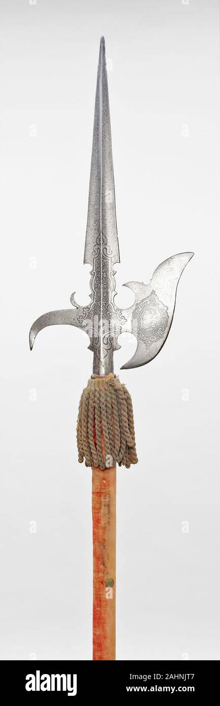 State Halberd. 1600–1610. Saxony. Steel, iron, wood, velvet, and attached tassel Pole arms (staff weapons) were used not only in warfare and hunting, but also in sporting combat and ceremonies. The term refers to a family of edged weapons attached to wooden staffs. With the exception of the lance, which remained the weapon of the mounted knight, all other staff weapons were wielded by men on foot by 1600. With the development of firearms and their introduction as infantry weapons, pole arms lost their importance on the field, and from the mid-16th century, they were reserved for use in sportin Stock Photo