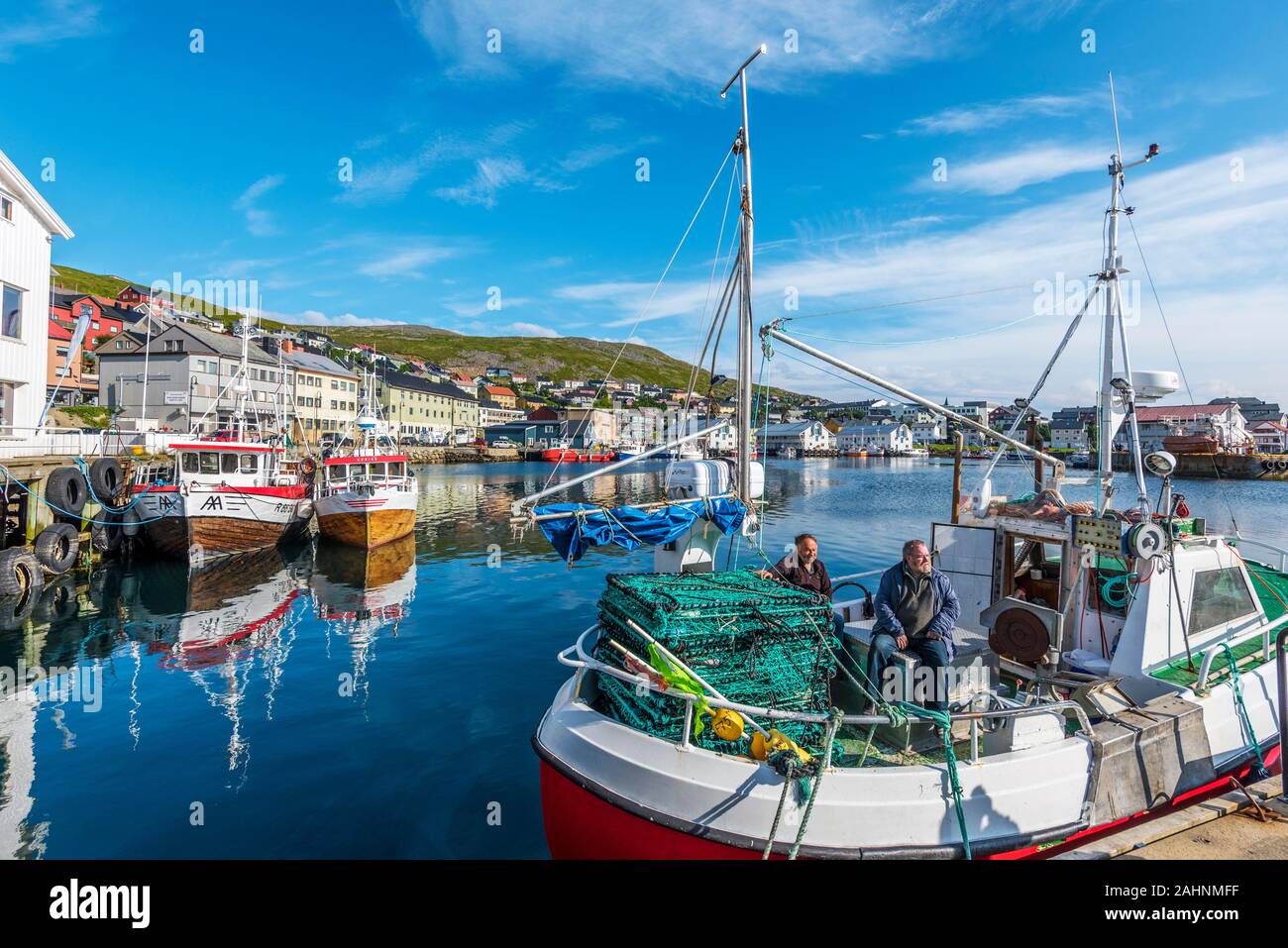 Honningsvag, Norway - August 10, 2017  Fishers boat with two fishmen in moored in the harbor of Honningsvag city in Mageroya island.  Nordkapp Municip Stock Photo