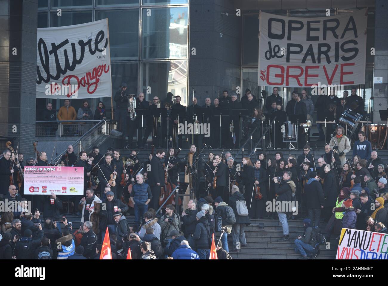*** STRICTLY NO SALES TO FRENCH MEDIA OR PUBLISHERS *** December 31, 2019 - Paris, France: Protesters show a giant check of 40.000 euros that symbolises the amount of money that the Infocom CGT, a Union branch, will give to Opera workers on strike. Musicians from the Opera Bastille gave a free open-air concert on the steps of the opera house to protest against the French government's pension reform plan. Stock Photo