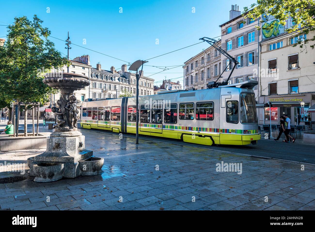 Saint-Etienne, France – July 29, 2019 Street view in Saint Etienne downtown. The tramway passing along the square Place du Peuple. The Statue with fou Stock Photo