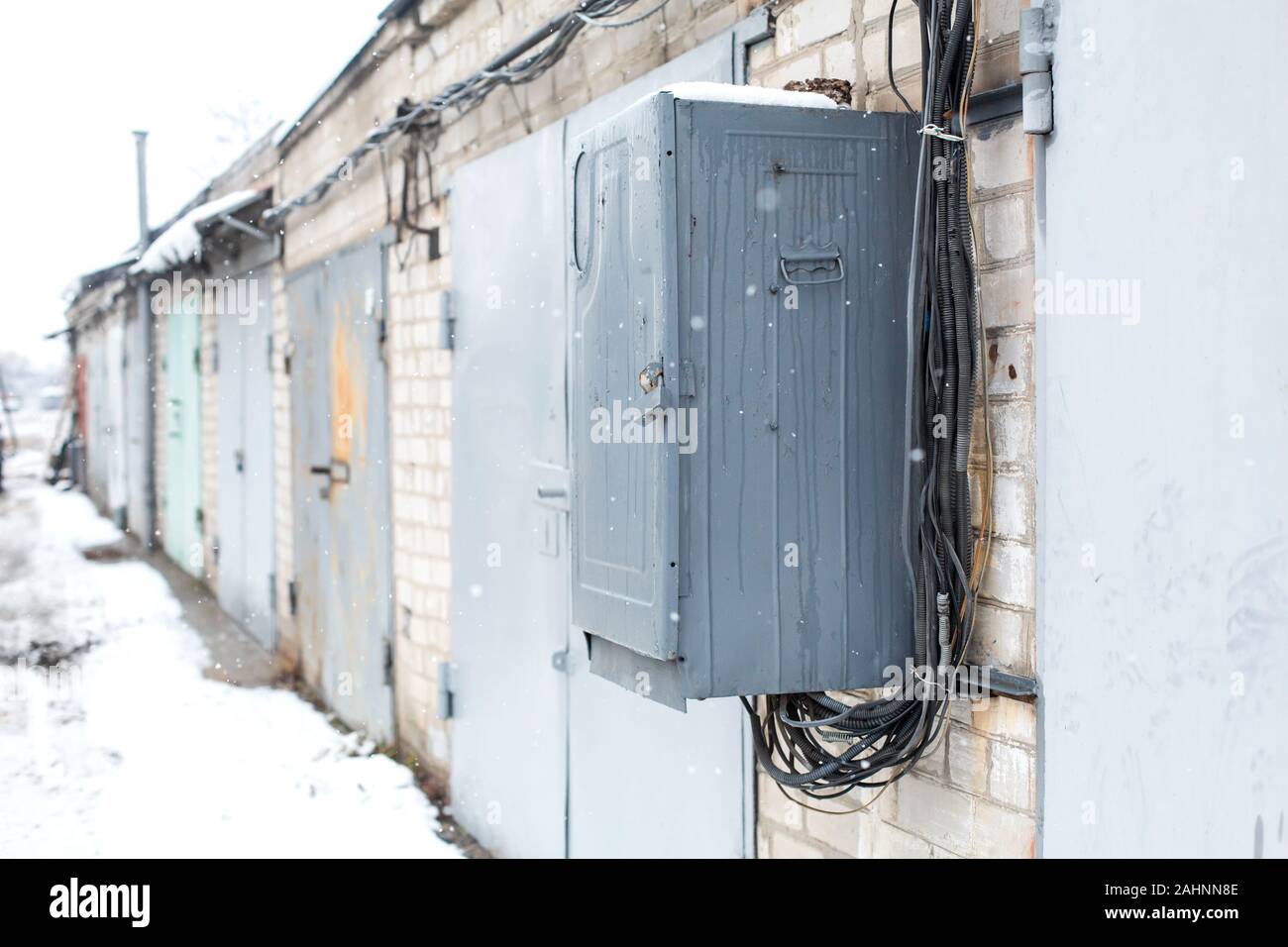 Old electrical communications box hanging on a wall in a garage cooperative. Stock Photo