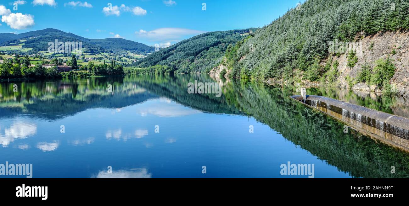 Dorlay reservoir collecting water from Dorlay river in French Auvergne-Rhone-Alpes region.  The part od the barrage concrete construction is at right. Stock Photo
