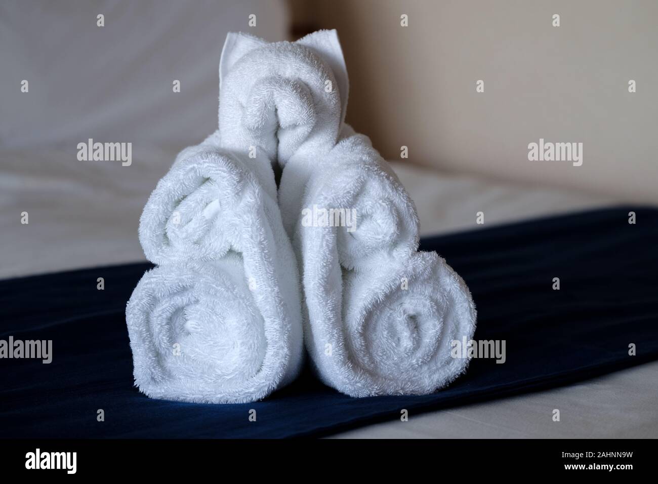 A towel origami animal made out of hotel room towels in the shape of a Bear. Its been left on the guests bed by room service Stock Photo