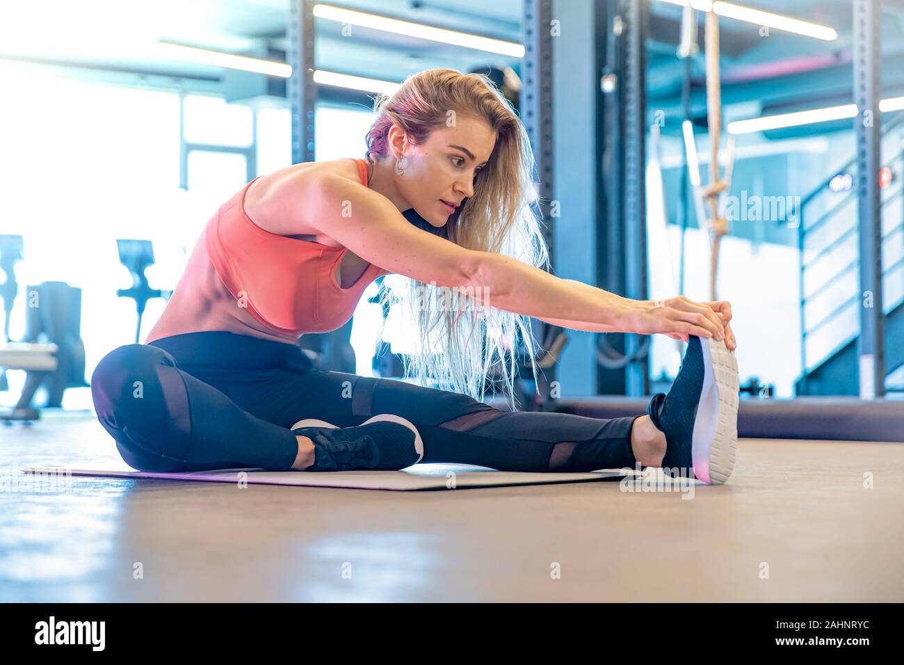 young pretty woman is stretching in the gym before exercise Stock Photo