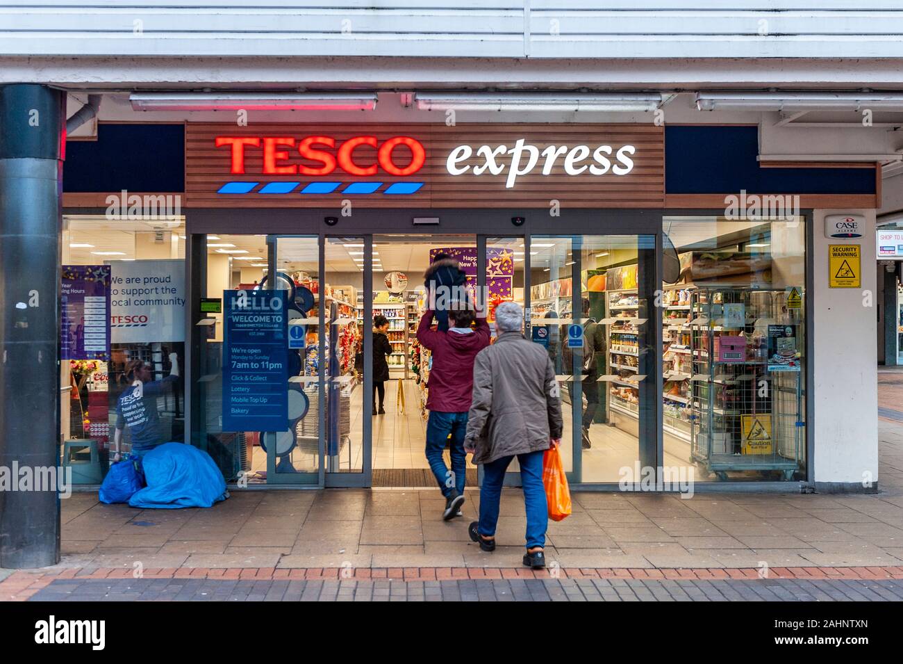 People walk in to Tesco Express Store in Coventry City Centre, West Midlands, UK. Stock Photo