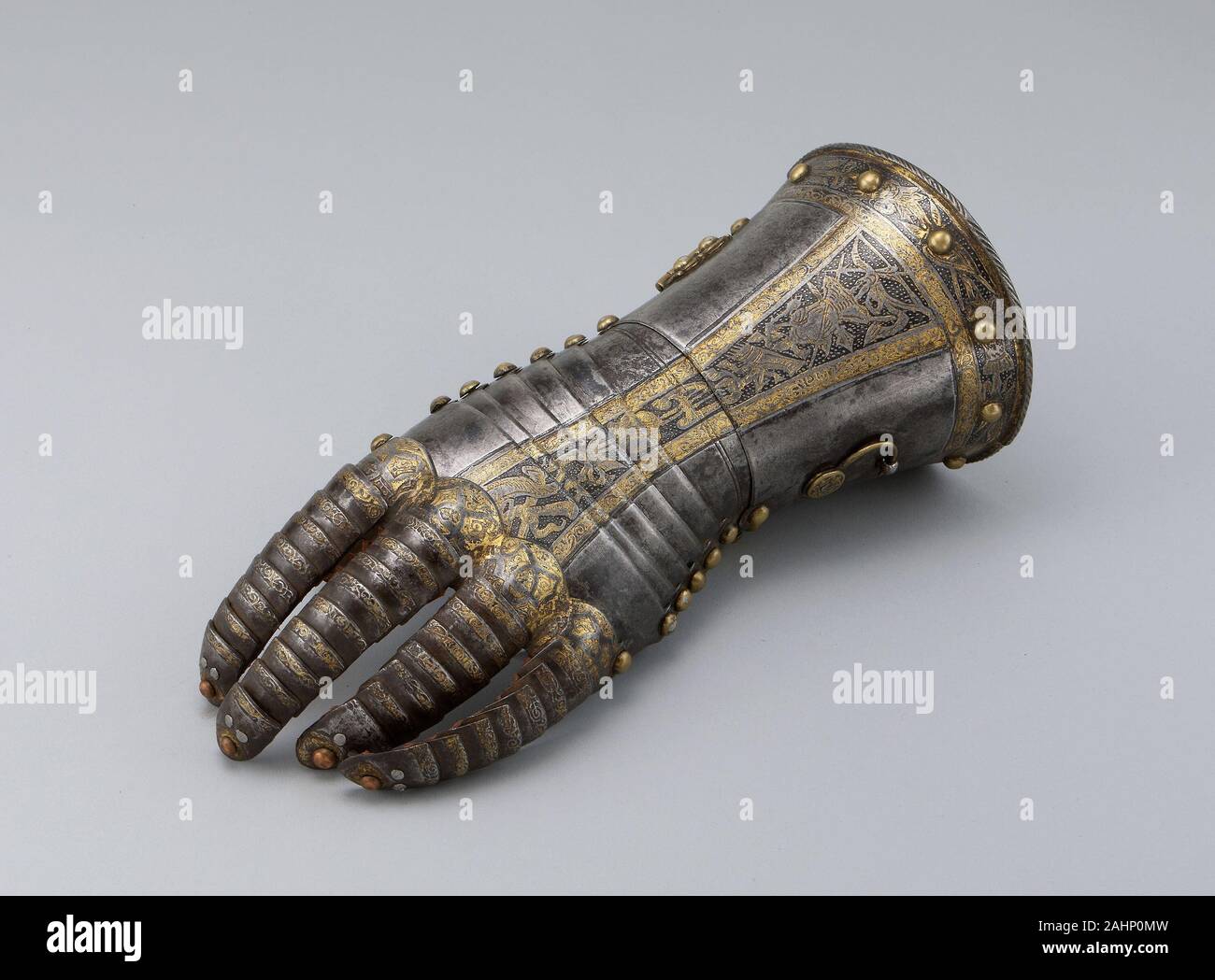 Anton Peffenhauser. Gauntlet from a Tournament Garniture of a Hapsburg Prince. 1560–1590. Augsburg. Steel, gilding, brass, and leather Stock Photo