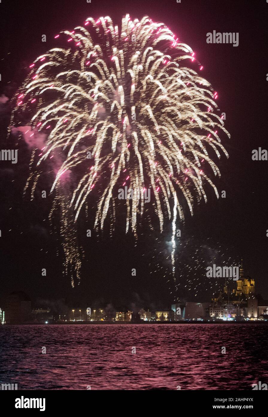 Stralsund, Germany. 31st Dec, 2019. A New Year's Eve firework display at the turn of the year 2020 lights up the port of the Hanseatic city of Stralsund. The fireworks on the harbour island took place in the early evening. Credit: Stefan Sauer/dpa/Alamy Live News Stock Photo