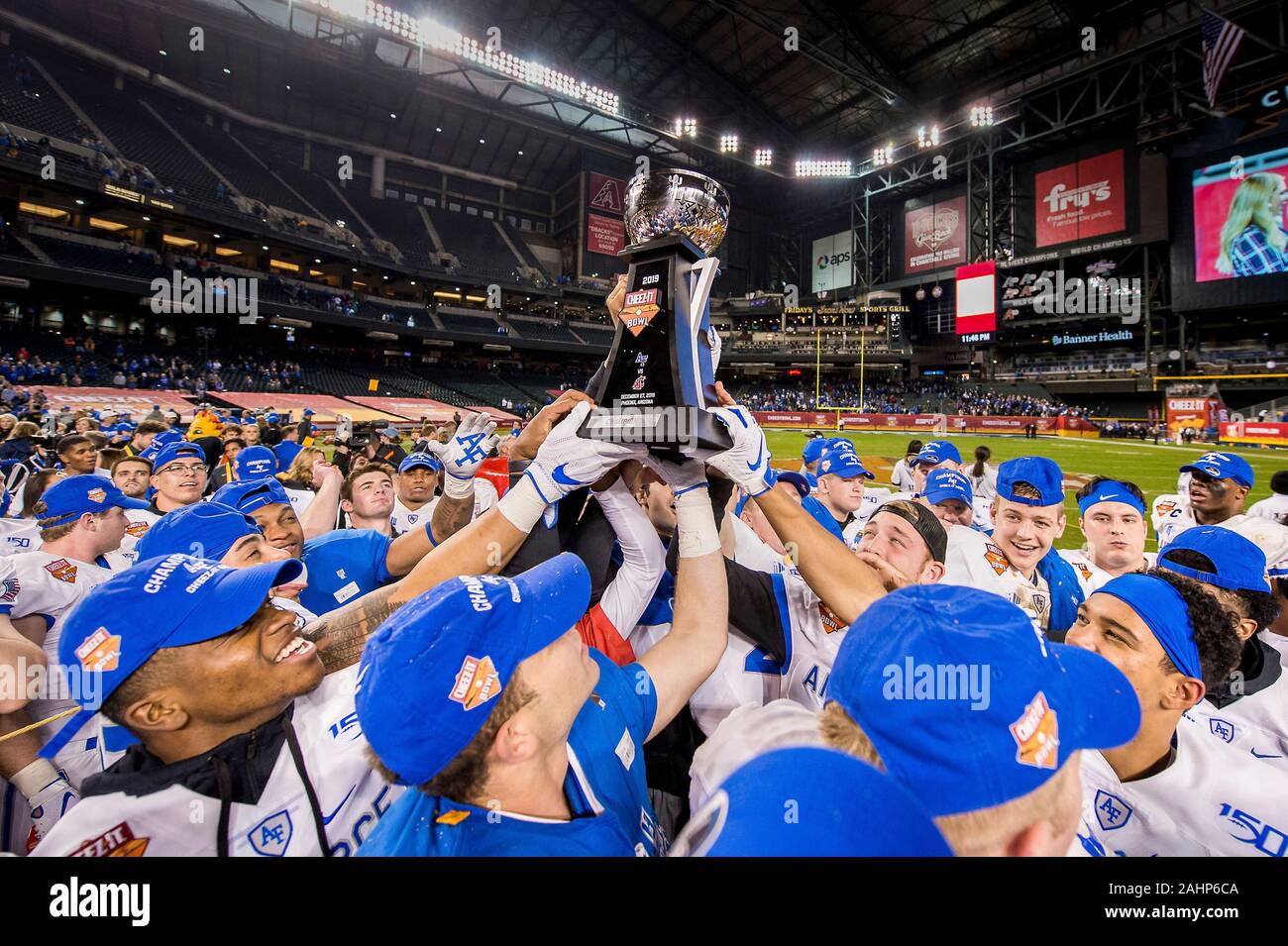 The U.S. Air Force Academy football players hold up the Cheez-It Bowl championship trophy following victory over Washington State University in the Cheez-It Bowl championship game at Chase Field December 27, 2019 in Phoenix, Arizona. Air Force defeated Washington State 31-21 to finish their season with an 11-2 record and an eight game win streak making it the third best season in program history. Stock Photo