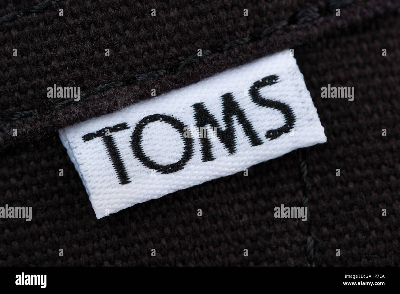 The Toms Shoes wordmark stitched onto a label which appears on the side of one of the company's footwear products. Stock Photo