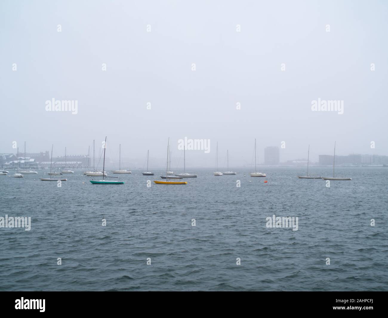 Small Sailing Ships Anchored In Boston Harbor On A Snowy Day Stock