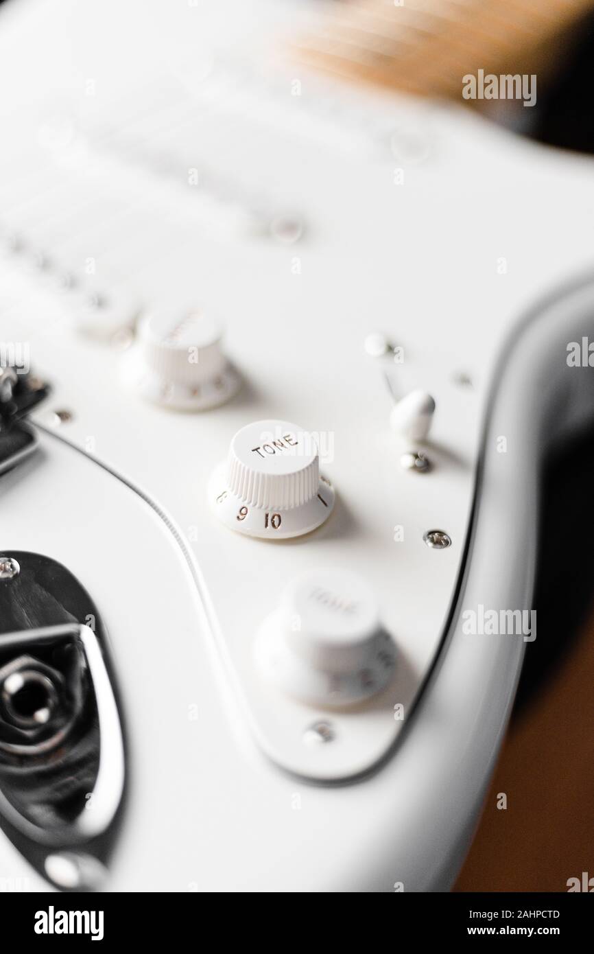Tone knob of white electric guitar with blurry background Stock Photo